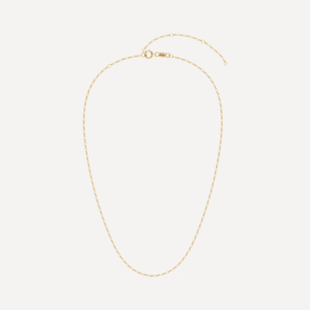 hero image of a solid gold figaro chain necklace against a cream background