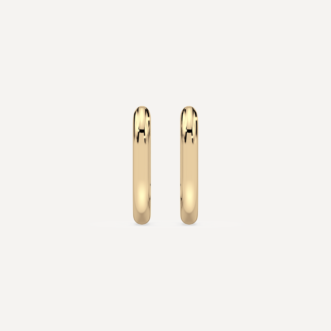 solid gold round hoops against a creamy white background by nadiya jewelry