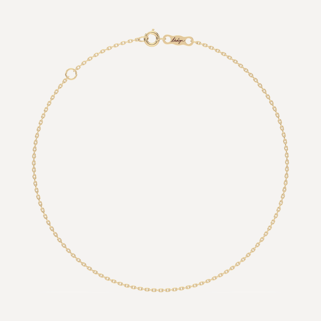 hero image of a solid gold cable chain bracelet against a cream background