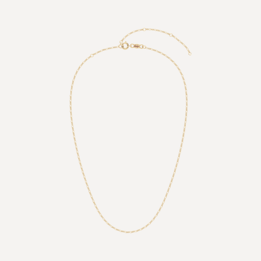 hero image of a solid gold figaro chain necklace against a cream background 