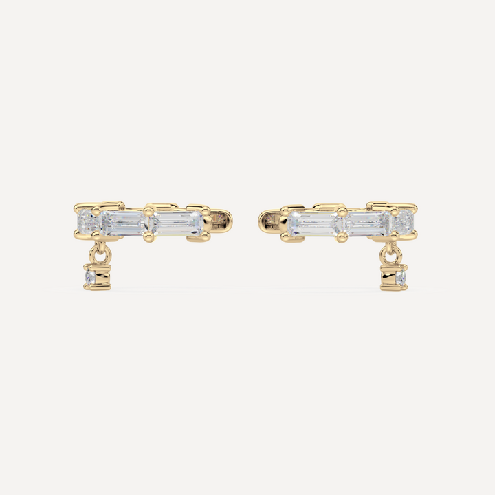solid gold baguette diamond ear cuffs on a creamy white background by nadiya jewelry