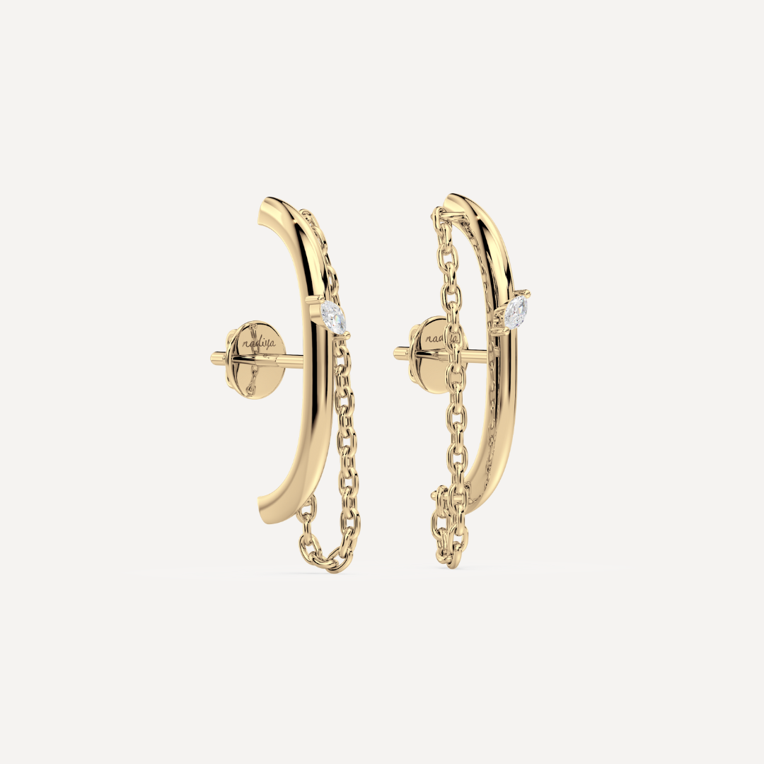 Solid gold ear suspender earrings with chain detail and a marquise diamond by Nadiya Jewelry on a white background