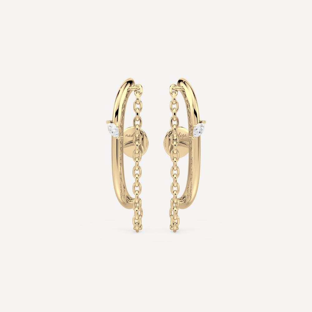 a solid gold earring ear suspender with chain detailing and a marquise diamond by nadiya jewelry 