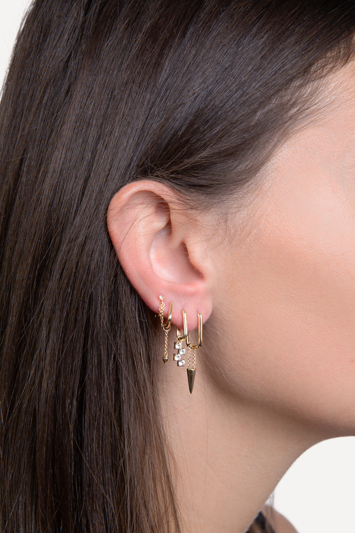 woman wearing 4  solid gold earrings ear piercings creating an earscape with diamond and chain details  
