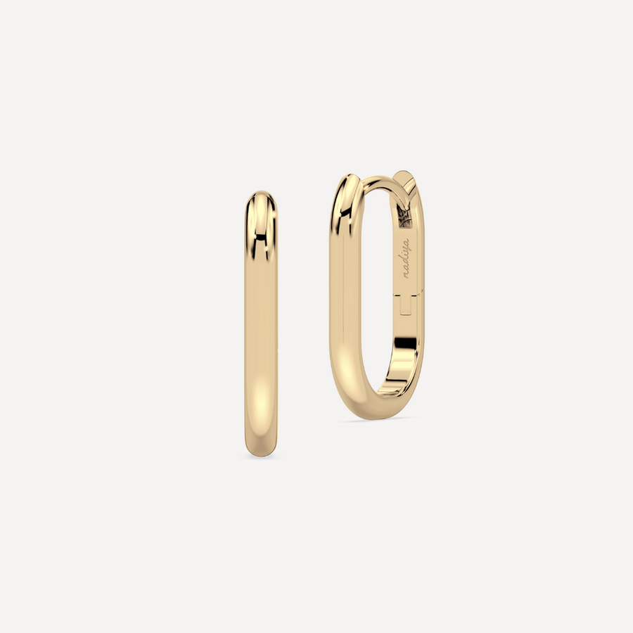 solid gold round hoops against a creamy white background by nadiya jewelry
