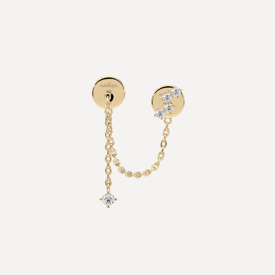 A solid gold earring with a small chain and multiple stones attached to it by nadiya jewelry