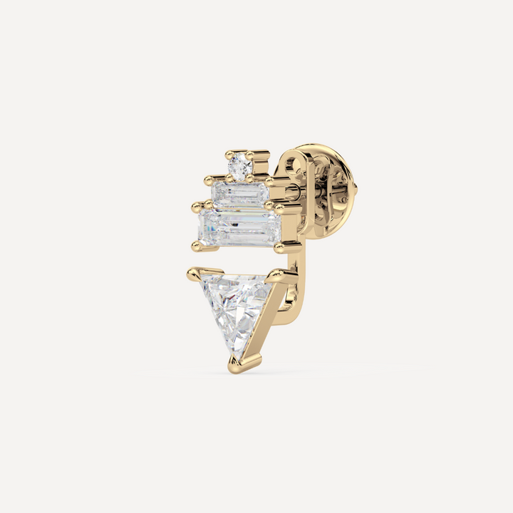 solid gold ladder ear jacket with lab grown diamonds. On the top there’s a round and two baguette diamonds and on the bottom there’s a trillion diamond on a creamy white background by nadiya jewelry
